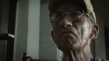 Movie still from “The Texas Chainsaw Massacre” (2003), directed by Marcus Nispel – An old man wearing glasses and a hat; Close Up shot, Low angle