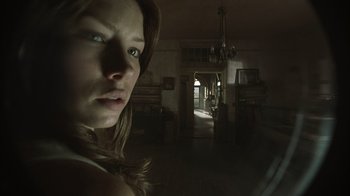 Movie still from “The Texas Chainsaw Massacre” (2003), directed by Marcus Nispel – A woman standing in a dark room looking at the camera; Close Up shot, Low angle