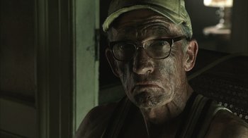 Movie still from “The Texas Chainsaw Massacre” (2003), directed by Marcus Nispel – An old man wearing glasses and a hat; Close Up shot, Low angle