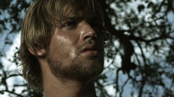 Movie still from “The Texas Chainsaw Massacre” (2003), directed by Marcus Nispel – A man's face with a tree in the background; Close Up shot, Low angle