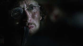 Movie still from “The Texas Chainsaw Massacre” (2003), directed by Marcus Nispel – A person wearing glasses and holding a gun; Close Up shot, Low angle