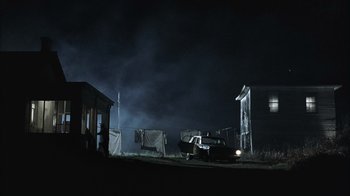 Movie still from “The Texas Chainsaw Massacre” (2003), directed by Marcus Nispel – An old truck parked in front of a house at night; Extreme Wide shot, Low angle