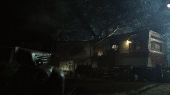 Movie still from “The Texas Chainsaw Massacre” (2003), directed by Marcus Nispel – An old truck parked in front of a trailer home at night; Extreme Wide shot, Low angle