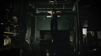 Movie still from “The Texas Chainsaw Massacre” (2003), directed by Marcus Nispel – A man standing on top of a table in a dark room; Wide shot, Low angle