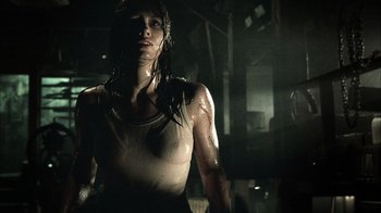 Movie still from “The Texas Chainsaw Massacre” (2003), directed by Marcus Nispel – A woman in a dark room with water on her body; Medium shot, Low angle