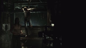 Movie still from “The Texas Chainsaw Massacre” (2003), directed by Marcus Nispel – A man standing on top of a metal platform; Wide shot, Low angle