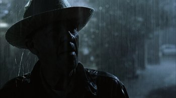 Movie still from “The Texas Chainsaw Massacre” (2003), directed by Marcus Nispel – A man wearing a hat in the rain; Close Up shot, Low angle