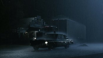 Movie still from “The Texas Chainsaw Massacre” (2003), directed by Marcus Nispel – A car driving down a street at night in the dark; Extreme Wide shot, Low angle