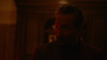 Movie still from “Full Circle” (2023), directed by Steven Soderbergh – A person wearing a suit; Close Up shot, Low angle