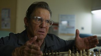Movie still from “Full Circle” (2023), directed by Steven Soderbergh – An older man is playing a game of chess; Close Up shot, Low angle