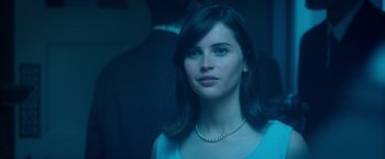 Movie still from “The Theory of Everything” (2014), directed by James Marsh – A beautiful woman with long black hair wearing a necklace; Close Up shot, Over the shoulder angle