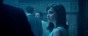 Movie still from “The Theory of Everything” (2014), directed by James Marsh – A woman standing in front of a group of people; Close Up shot, Over the shoulder angle