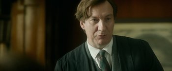 Movie still from “The Theory of Everything” (2014), directed by James Marsh – A person wearing a suit and tie; Close Up shot, Low angle