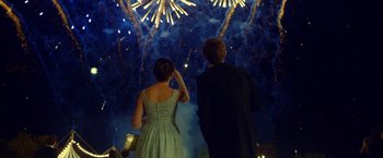 Movie still from “The Theory of Everything” (2014), directed by James Marsh – A man and a woman standing in front of a fireworks display; Medium shot, Over the shoulder angle