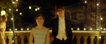 Movie still from “The Theory of Everything” (2014), directed by James Marsh – A man and a woman posing for a picture; Medium shot, Low angle
