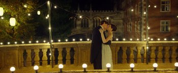 Movie still from “The Theory of Everything” (2014), directed by James Marsh – A man and a woman kissing in front of a building; Wide shot, Low angle