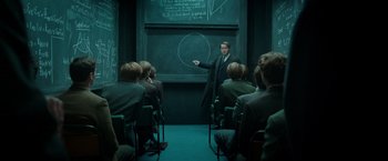 Movie still from “The Theory of Everything” (2014), directed by James Marsh – A man standing in front of a group of people; Wide shot, High angle