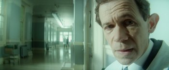 Movie still from “The Theory of Everything” (2014), directed by James Marsh – An older man in a white shirt in a hospital hallway; Close Up shot, Low angle