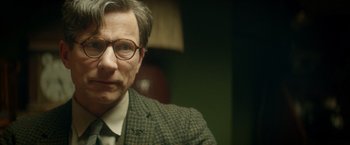 Movie still from “The Theory of Everything” (2014), directed by James Marsh – A person wearing glasses and a suit; Close Up shot, Over the shoulder angle
