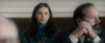 Movie still from “The Theory of Everything” (2014), directed by James Marsh – A woman in a blue jacket is looking at the camera; Close Up shot, Over the shoulder angle