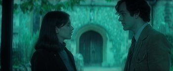 Movie still from “The Theory of Everything” (2014), directed by James Marsh – A woman and a man standing next to each other in front of a building; Medium shot, Over the shoulder angle
