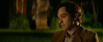 Movie still from “The Theory of Everything” (2014), directed by James Marsh – A person wearing a suit and tie; Close Up shot, Over the shoulder angle