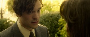 Movie still from “The Theory of Everything” (2014), directed by James Marsh – A man in a suit and tie standing next to a woman in a suit; Close Up shot, Over the shoulder angle