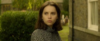 Movie still from “The Theory of Everything” (2014), directed by James Marsh – A young woman with long brown hair wearing a black and white dress; Close Up shot, Over the shoulder angle
