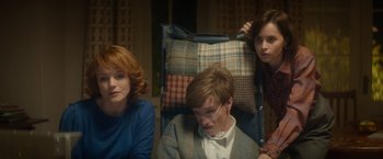 Movie still from “The Theory of Everything” (2014), directed by James Marsh – A group of people sitting in a chair; Medium shot, High angle