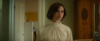 Movie still from “The Theory of Everything” (2014), directed by James Marsh – A woman in a white dress standing in front of a window; Close Up shot, Over the shoulder angle