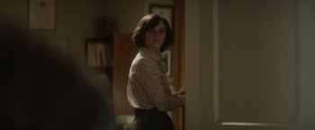 Movie still from “The Theory of Everything” (2014), directed by James Marsh – A woman standing in front of a wall in a room; Medium shot, Over the shoulder angle