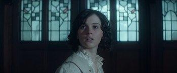 Movie still from “The Theory of Everything” (2014), directed by James Marsh – A young woman in front of a stained glass window; Close Up shot, Over the shoulder angle