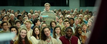 Movie still from “The Theory of Everything” (2014), directed by James Marsh – A large group of people sitting in a room; Wide shot, High angle