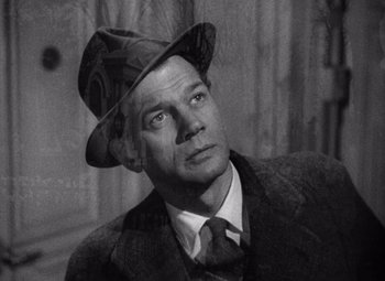 Movie still from “The Third Man” (1949), directed by Carol Reed – A man wearing a suit and a hat looking to his left; Close Up shot, Low angle