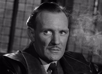 Movie still from “The Third Man” (1949), directed by Carol Reed – An old black and white photo of a man smoking a cigarette; Close Up shot, Low angle