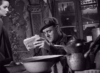 Movie still from “The Third Man” (1949), directed by Carol Reed – A man sitting at a table with a sandwich in front of him; Medium shot, Low angle