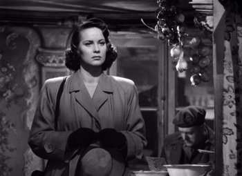 Movie still from “The Third Man” (1949), directed by Carol Reed – A woman wearing a hat and gloves in a room; Medium shot, Over the shoulder angle