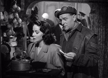 Movie still from “The Third Man” (1949), directed by Carol Reed – A man and a woman looking at something on a table; Medium shot, Low angle