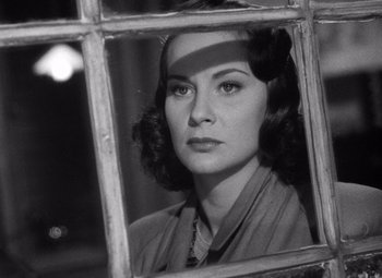 Movie still from “The Third Man” (1949), directed by Carol Reed – A black - and - white photo of a woman looking through a window; Close Up shot, Low angle