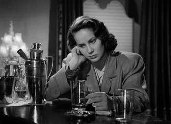 Movie still from “The Third Man” (1949), directed by Carol Reed – A woman sitting at a table with a drink in front of her; Close Up shot, High angle