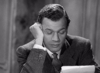 Movie still from “The Third Man” (1949), directed by Carol Reed – A black and white photo of a man sitting at a desk; Close Up shot, Over the shoulder angle