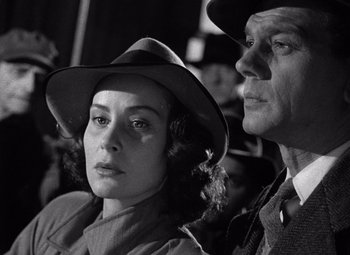 Movie still from “The Third Man” (1949), directed by Carol Reed – A man and a woman wearing hats in a crowd; Close Up shot, Low angle