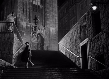 Movie still from “The Third Man” (1949), directed by Carol Reed – A woman walking down a set of stairs; Extreme Wide shot, Low angle