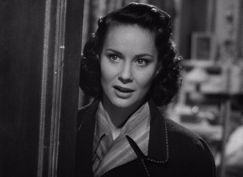 Movie still from “The Third Man” (1949), directed by Carol Reed – A woman in a suit and tie standing in front of a window; Close Up shot, High angle