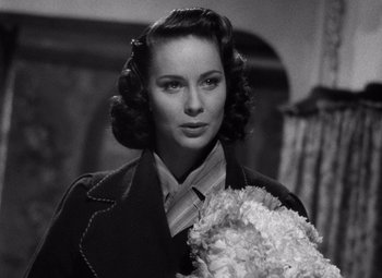Movie still from “The Third Man” (1949), directed by Carol Reed – A black - and - white photo of a woman holding flowers; Close Up shot, High angle