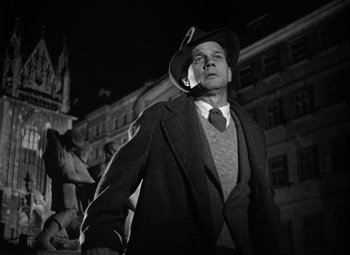 Movie still from “The Third Man” (1949), directed by Carol Reed – A man wearing a hat and a coat; Medium shot, Low angle