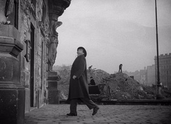 Movie still from “The Third Man” (1949), directed by Carol Reed – An old photo of a man walking on the street; Wide shot, Low angle