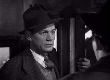 Movie still from “The Third Man” (1949), directed by Carol Reed – A black and white photo of a man in a suit and hat; Close Up shot, Low angle