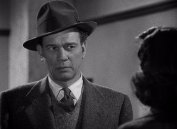 Movie still from “The Third Man” (1949), directed by Carol Reed – A man wearing a suit and a hat; Close Up shot, Over the shoulder angle