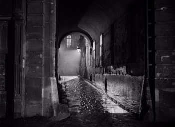 Movie still from “The Third Man” (1949), directed by Carol Reed – An alley way with a light shining through a window; Extreme Wide shot, High angle